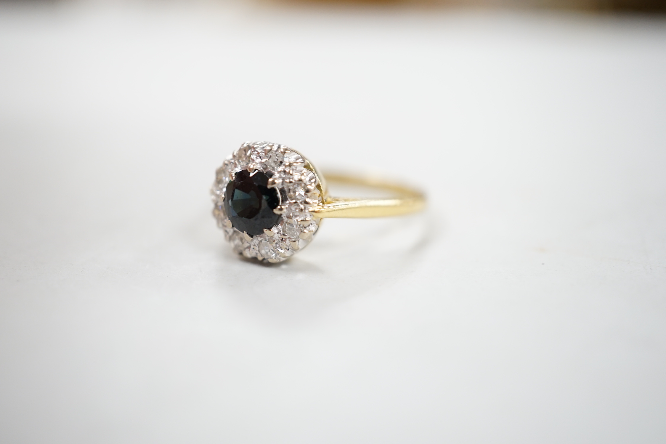 A 1960's 18ct gold, sapphire and diamond set circular cluster ring, size N, gross weight 3.7 grams.